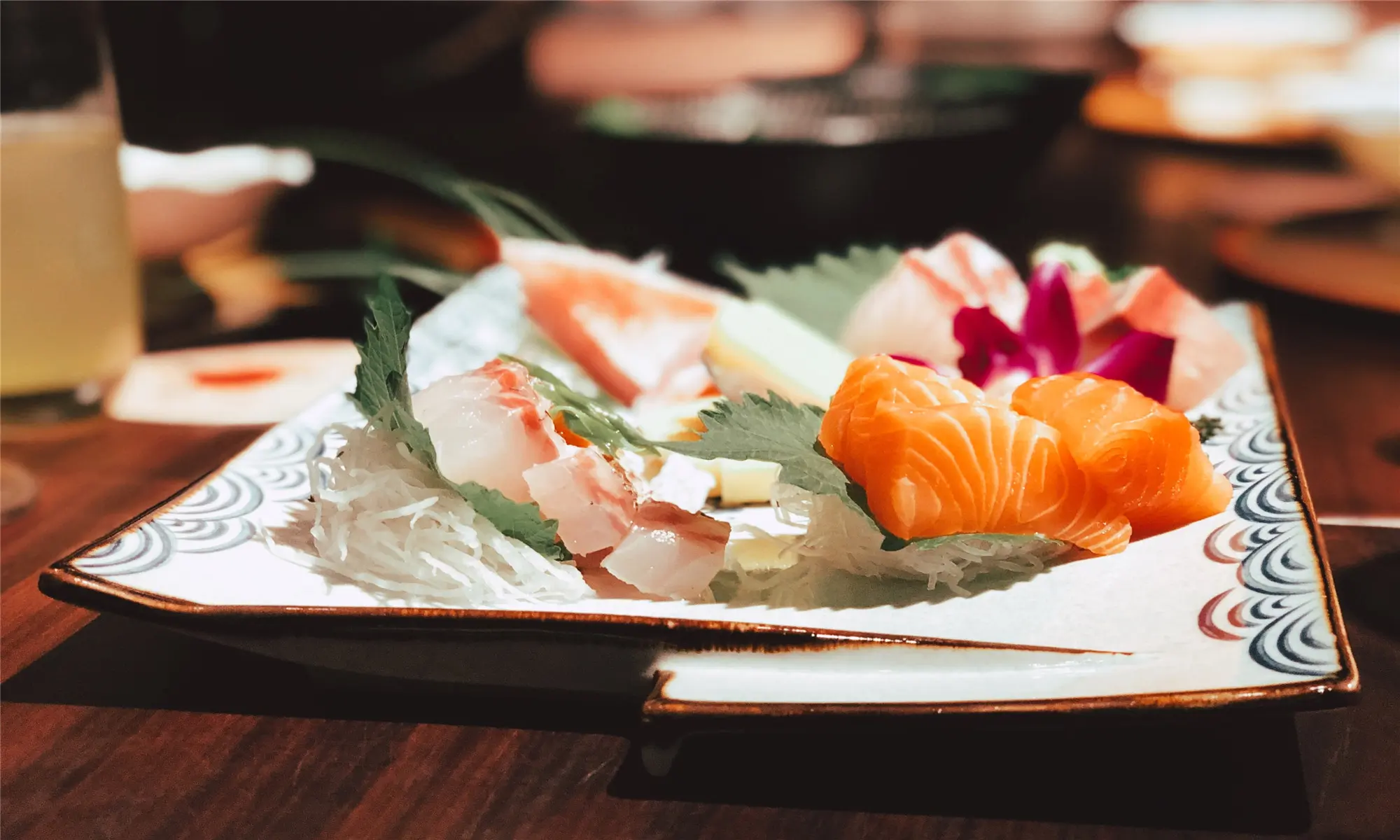 Assorted sashimi platter with fresh raw fish, served on a decorative plate with shredded radish at Happy Sushi Japanese restaurant in Santa Clara