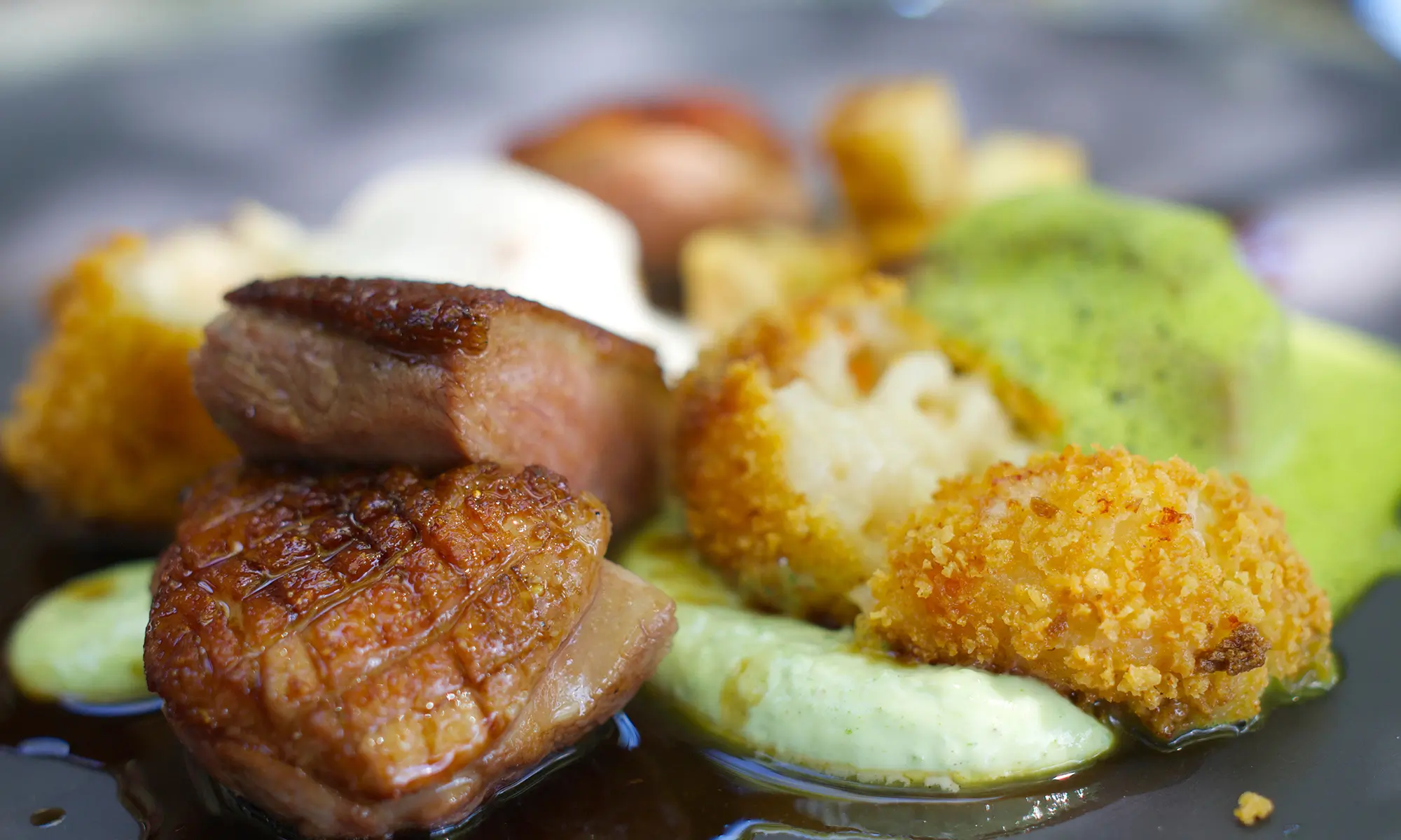 Pan - seared duck with crispy crust, served with fried cauliflower and green sauce at Happy Sushi Japanese restaurant in Santa Clara