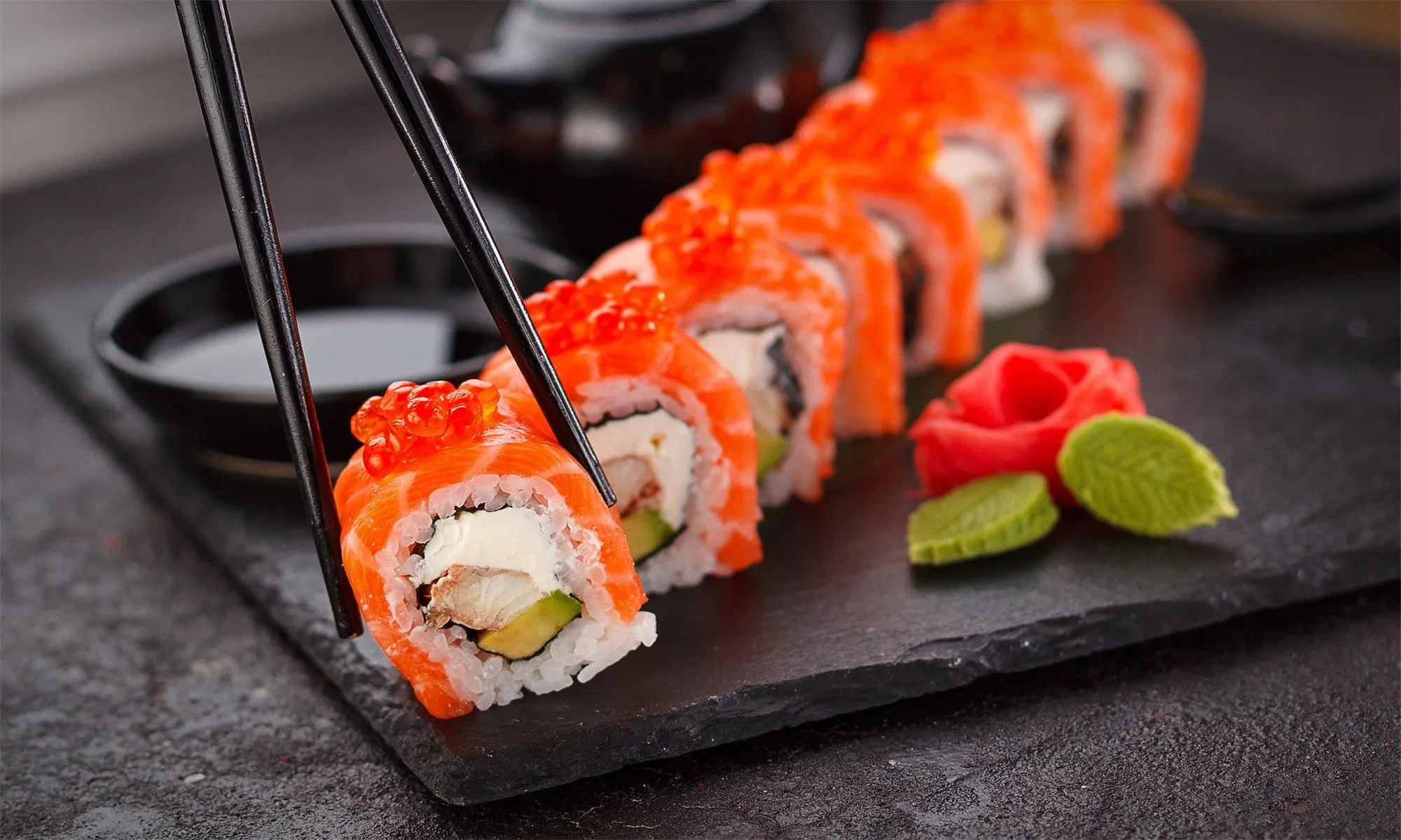 Salmon roll with avocado, cream cheese, and fish roe, served with pickled ginger and wasabi at Happy Sushi Japanese restaurant in Santa Clara